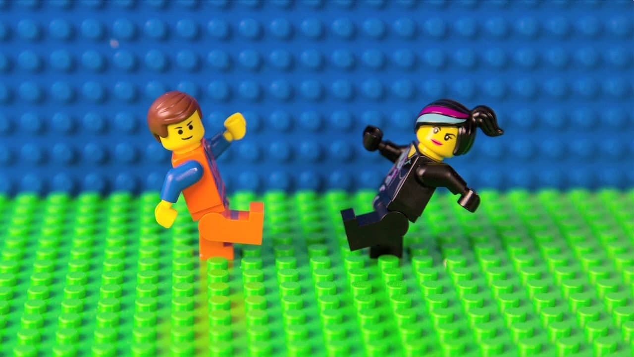 Emmet and Wyldstyle LEGO figures running across a green baseplate